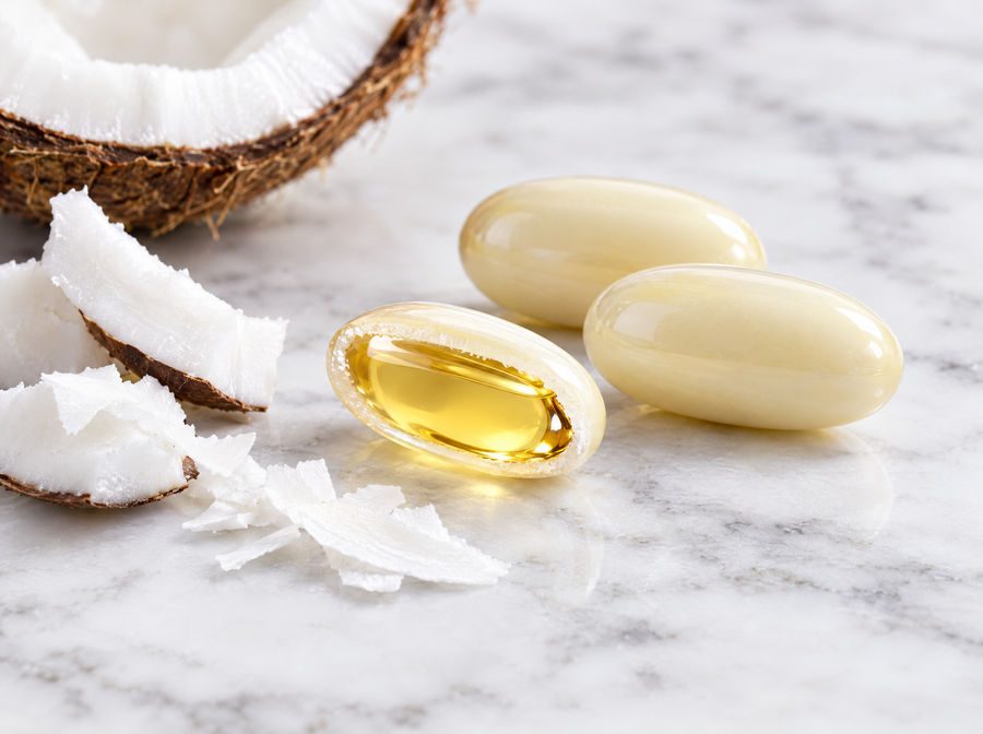 A softgel cut open showing coconut oil inside
